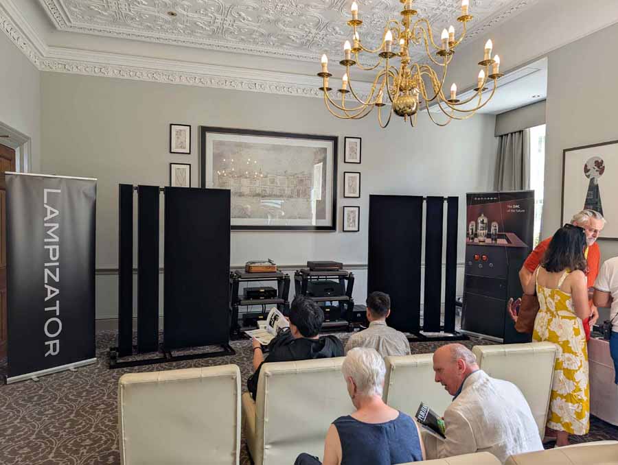 HiFi NETWORK
Victor, from HiFi Network, talked me through this cool, ultra-simple system. The stars of the show were a pair of ELAC Debut Reference 3.0 (£1399), which they claim, “builds on the success of Debut 3.0 with redesigned driver technology, refined cabinet design, and a true 3-way floorstanding architecture.” Also in the range, both with 2-way bass reflex, are: standmounts (£749) and a centre channel speaker (£449). These come in five different finishes, including: black, green, satin white, titanium, and walnut.
An AVM CS30.3 streaming amplifier was doing an admirable job of driving the ELACs, even with some laid back, and gentle smooth jazz. Having reviewed the Carina BS 243.4 bookshelf loudspeakers from the brand, I can testify their speakers benefit from an amp that can drive them, to bring out their best. This amp had it covered, with ease, and was also a lovely-looking box in chrome finish (£3700). Also on display, but not in the system at the time I was in the room, was an Inspiration C2.3 streaming amp, in a gorgeous gold satin colour. The option of this finish is exclusive to this model but doesn’t carry any additional premium. Gorgeous kit.