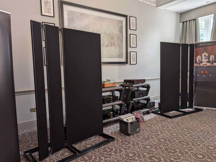 HiFi NETWORK
Victor, from HiFi Network, talked me through this cool, ultra-simple system. The stars of the show were a pair of ELAC Debut Reference 3.0 (£1399), which they claim, “builds on the success of Debut 3.0 with redesigned driver technology, refined cabinet design, and a true 3-way floorstanding architecture.” Also in the range, both with 2-way bass reflex, are: standmounts (£749) and a centre channel speaker (£449). These come in five different finishes, including: black, green, satin white, titanium, and walnut.
An AVM CS30.3 streaming amplifier was doing an admirable job of driving the ELACs, even with some laid back, and gentle smooth jazz. Having reviewed the Carina BS 243.4 bookshelf loudspeakers from the brand, I can testify their speakers benefit from an amp that can drive them, to bring out their best. This amp had it covered, with ease, and was also a lovely-looking box in chrome finish (£3700). Also on display, but not in the system at the time I was in the room, was an Inspiration C2.3 streaming amp, in a gorgeous gold satin colour. The option of this finish is exclusive to this model but doesn’t carry any additional premium. Gorgeous kit.